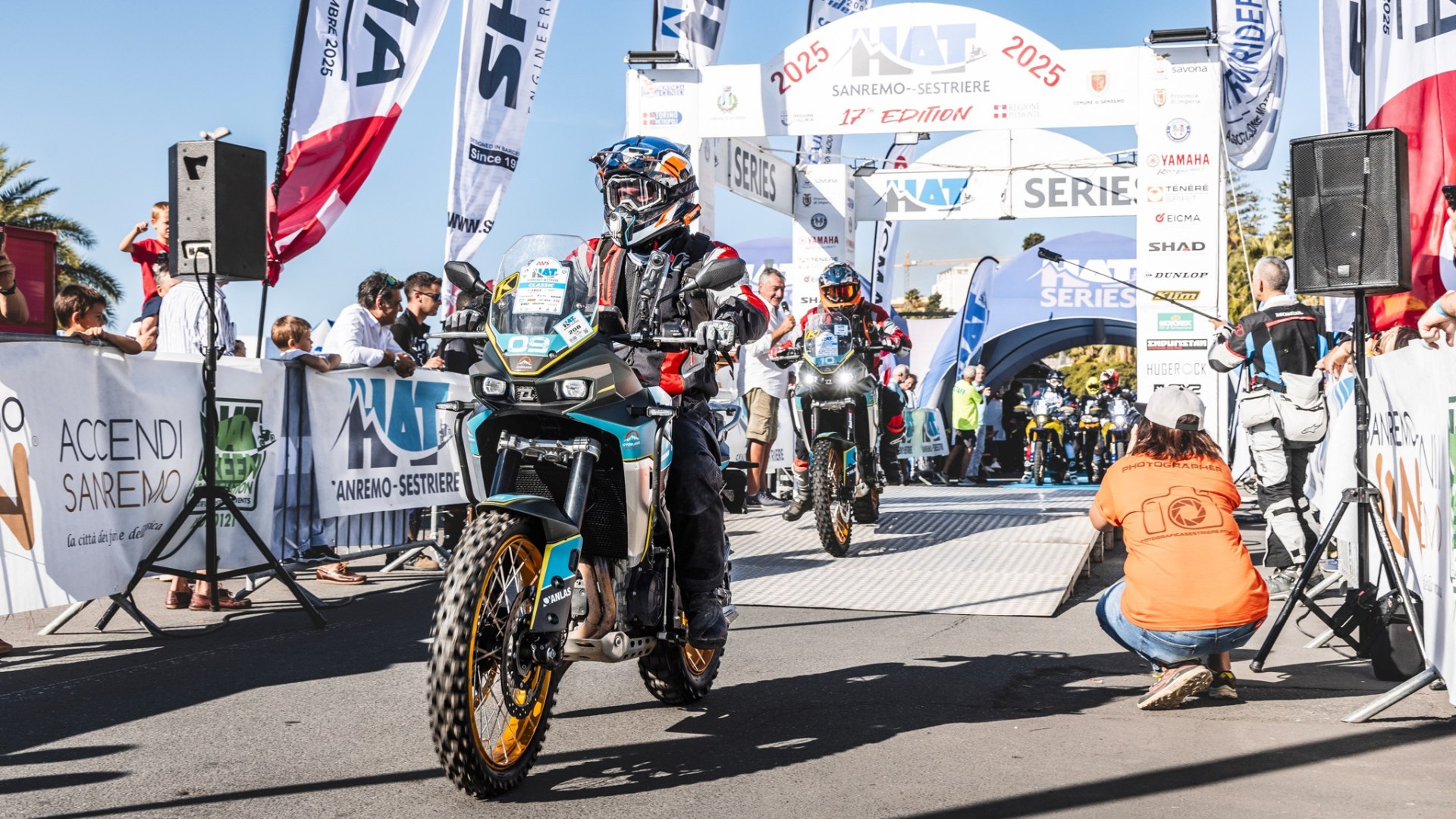 Pilota in sella a una moto, percorso in montagna, partecipanti a un evento di moto